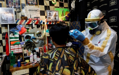 Foto: Tukang Pangkas Rambut Pakai Kostum APD