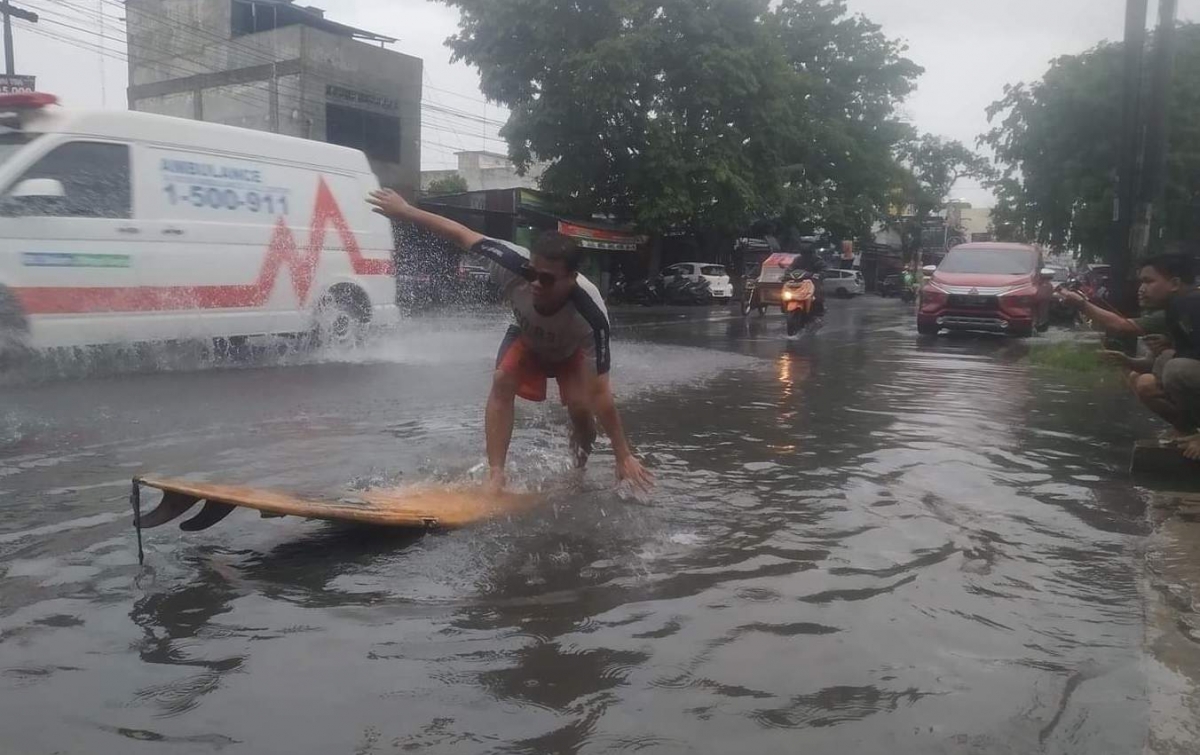 Kritik Pemko Medan, 3 Pemuda Memancing dan Berselancar saat Banjir