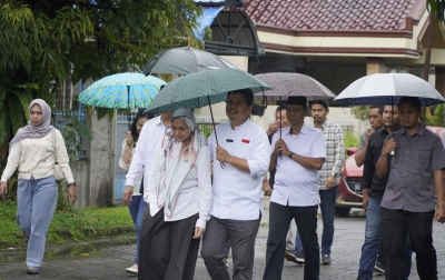 Sepayung Bersama Istri, Prof Ridha Ditemani Ketiga Putrinya Nyoblos di TPS 23 Medan Selayang