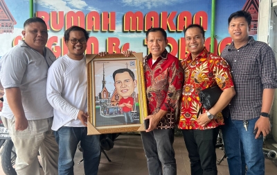 Senyum Semringah Landen Marbun saat Terima Foto Karikatur dari DPC GAMKI Medan