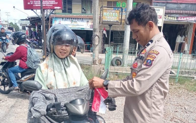 Sambut HUT RI, Polsek Kualuh Hulu Pasangkan Bendera Merah Putih ke Pengendara